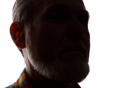 Portrait of a old man, unshaven, with beard, side view - dark isolated silhouetteの写真素材