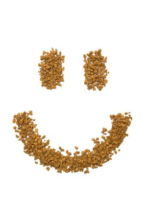 Dry instant coffee granules in the shape of a smiley - brown texture, on a white backgroundの写真素材