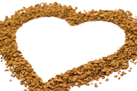Dry instant coffee granules in the shape of a heart - brown texture, on a white backgroundの写真素材