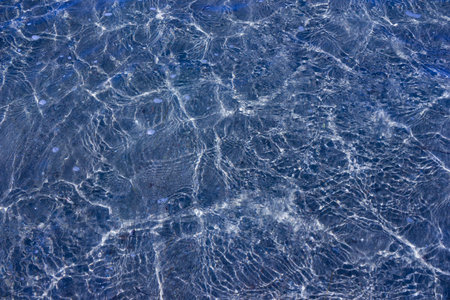 Texture of transparent sea waves in sunlight - top view
