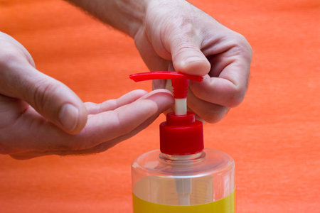 Men's hands with a liquid soap dispenser, alcohol-based antiseptics - hand washing, hygiene,...