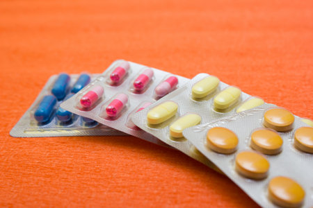 Many tablets and capsules on a white background - protection against flu during quarantine,...