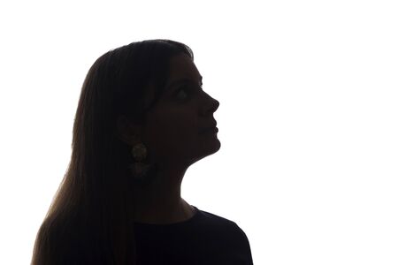 Portrait of a beautiful young girl looking up concept and symbol of thinking and dreams - silhouette, isolateの写真素材