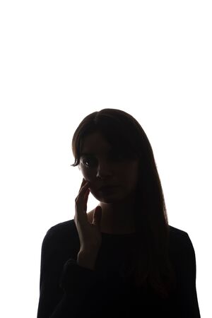 Portrait of a beautiful young girl with her hair looking in front of herself a concept and a symbol of thinking and feelings about beauty and skin - silhouette, isolateの写真素材