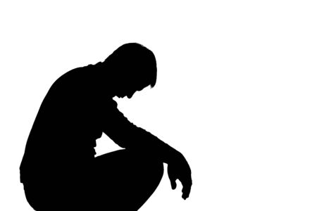 Young man with grief dropped his arms - dark silhouetteの写真素材