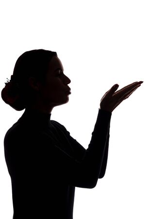 Young woman shows his hands forward, sending a kiss - silhouetteの写真素材