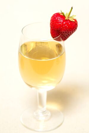 Red and ripe strawberry on the glass with a yellow drink, alcoholの写真素材