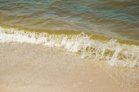 Sea wave on a sandy beach in summerの写真素材