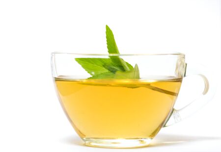 Glass transparent cup with tea and green mint leaf - on a white backgroundの写真素材