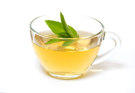 Glass transparent cup with tea and green mint leaf - on a white backgroundの写真素材