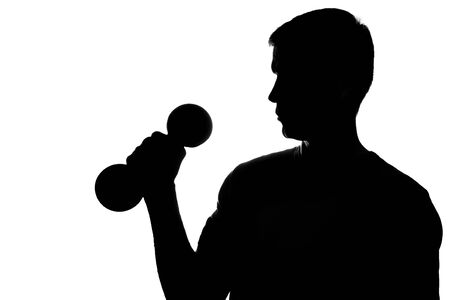 Young man with dumbbells in hand - silhouetteの写真素材