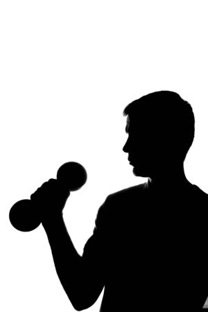 Young man with dumbbells in hand - silhouetteの写真素材