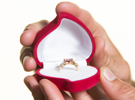 Ring in an open box in a man's hand, the proposal - isolate on a white background