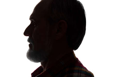 Portrait of a old man, unshaven, with beard, side view - dark isolated silhouetteの写真素材