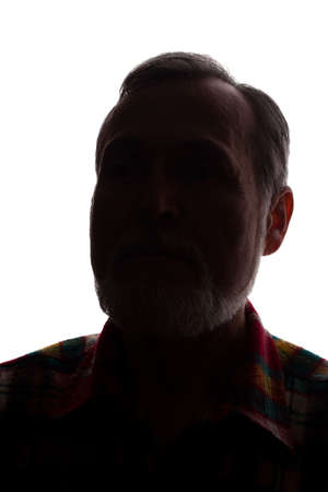 Portrait of a old man, unshaven, with beard, front view - dark isolated silhouetteの写真素材