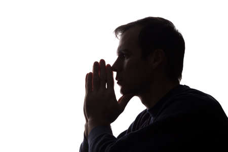 The young man thought his head propped on his hand - silhouetteの写真素材