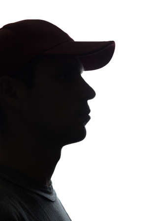 Portrait of a young man in cap, half view - silhouetteの写真素材