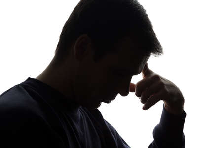 The young man thought his head propped on his hand - silhouetteの写真素材
