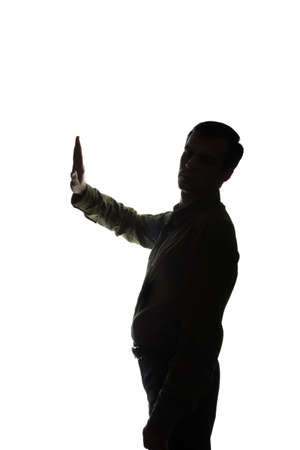 Portrait of a young man with his hands raised, side view - silhouetteの写真素材