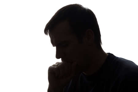 The young man thought his head propped on his hand - silhouetteの写真素材