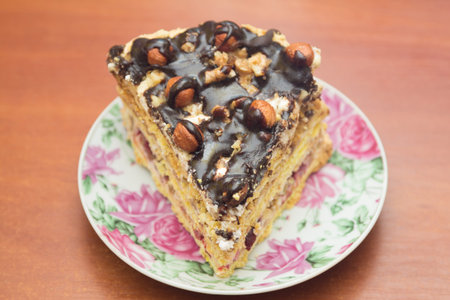 Piece of cake with hazelnuts and chocolate - in a saucer, background