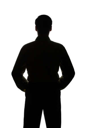 Portrait of a young man, hands on hips, front view - silhouetteの写真素材