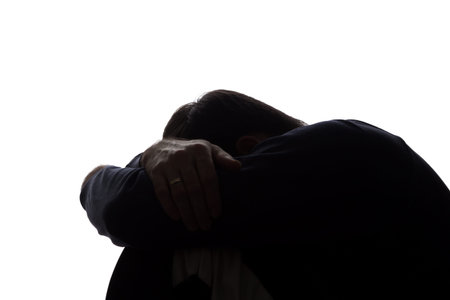 A young man with grief tearing at her hair - silhouette