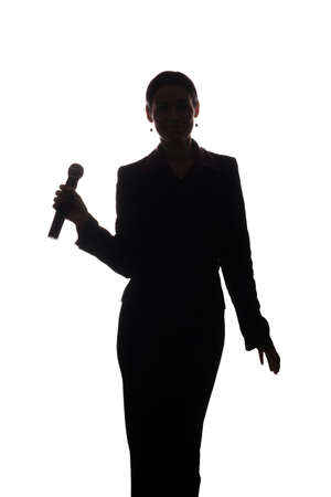 Young woman singing into the microphone, raising his hands - silhouetteの写真素材