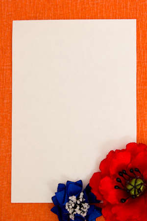 Sheet of clean paper and bright artificial flowers - colorful, beautiful backgroundの写真素材