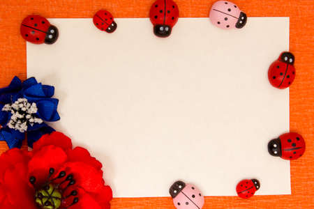 Frame of bright artificial flowers and ladybirds - a multi-colored, beautiful backgroundの写真素材