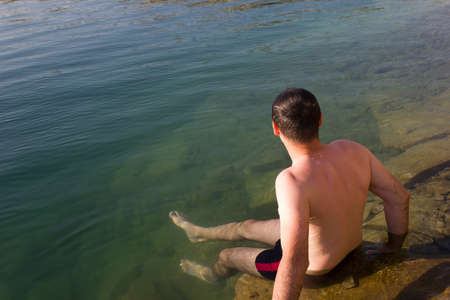Male young swimmer on the water - background summer sunny seaの写真素材