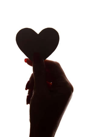 Symbol of heart and love in a female hand - silhouette, isolatedの写真素材