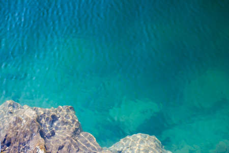 Texture of water surface under the rays of the sun water stones waves - underwater world, backgroundの写真素材