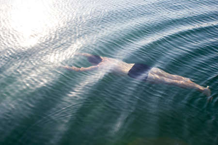 Male young swimmer underwater - background summer sunny sea, swimming lessons, divingの写真素材