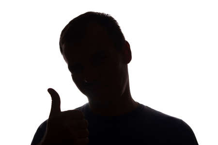 Silhouette smiling young man hand shows symbol of a ok - silhouetteの写真素材