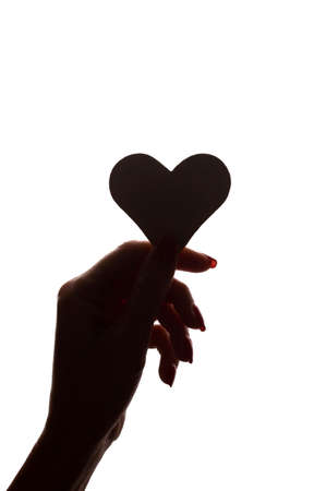 Symbol of heart and love in a female hand - silhouette, isolatedの写真素材