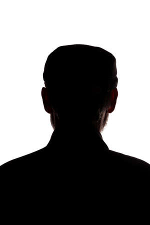 Portrait of a old man, in a peaked cap, with beard, rear view - dark isolated silhouetteの写真素材