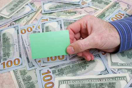 Paper for text in hand on the background of dollars on the table close-up, one hundred dollars washington, one thousand - texture, backgroundの写真素材