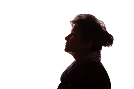 Dark silhouette of an elderly woman, a pensioner with curly hair - isolate, white backgroundの写真素材