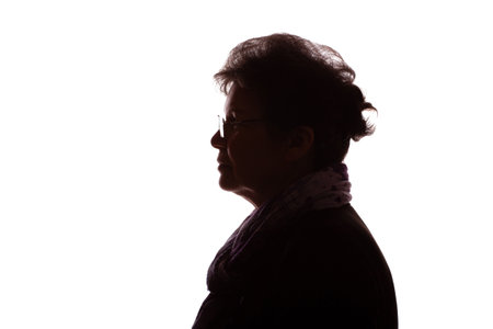 Dark silhouette of an elderly woman, a pensioner with curly hair in glasses - isolate, white backgroundの写真素材