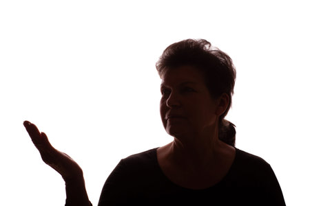 Dark silhouette of an elderly woman points his hand to the side - isolate, white backgroundの写真素材