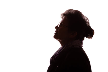 Dark silhouette of an elderly woman, a pensioner with curly hair in glasses - isolate, white backgroundの写真素材