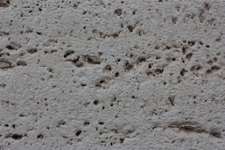 Fragment of the old facade of a house made of travertine, Italy, Rome