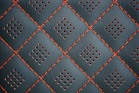 Orange contrast thread on perforated natural black leather car seat close-upの写真素材
