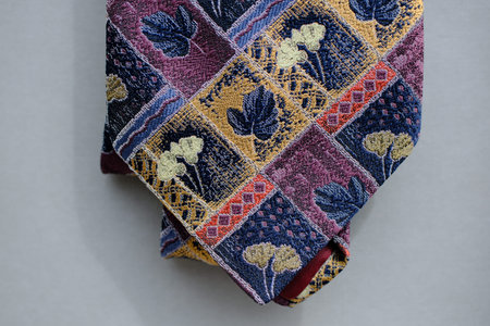 Classic tie fabric texture close-up with colorfull pattern on a gray background