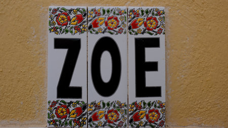 Greek origin female name Zoe (life), laid out on decorative tiles on the house wall, Santorini, Greeceの写真素材