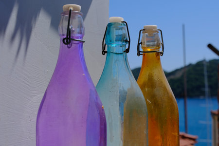 3 colored bottles of different colors as part of the home exterior decoration, Skiathos island, Greeceの写真素材