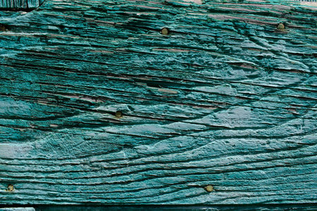 Old peeling green paint texture on a fragment of a wooden fence