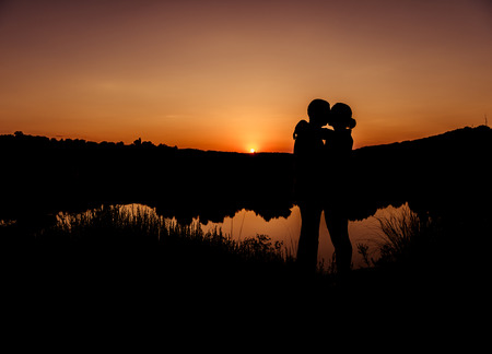 romantic sunset couple silhouettesの写真素材