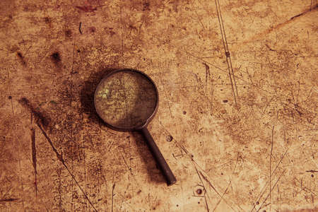 old dusty magnifier on scratched wooden vintage surfaceの写真素材